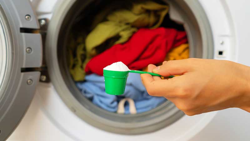 Colocar tira-nódoas na máquina da roupa